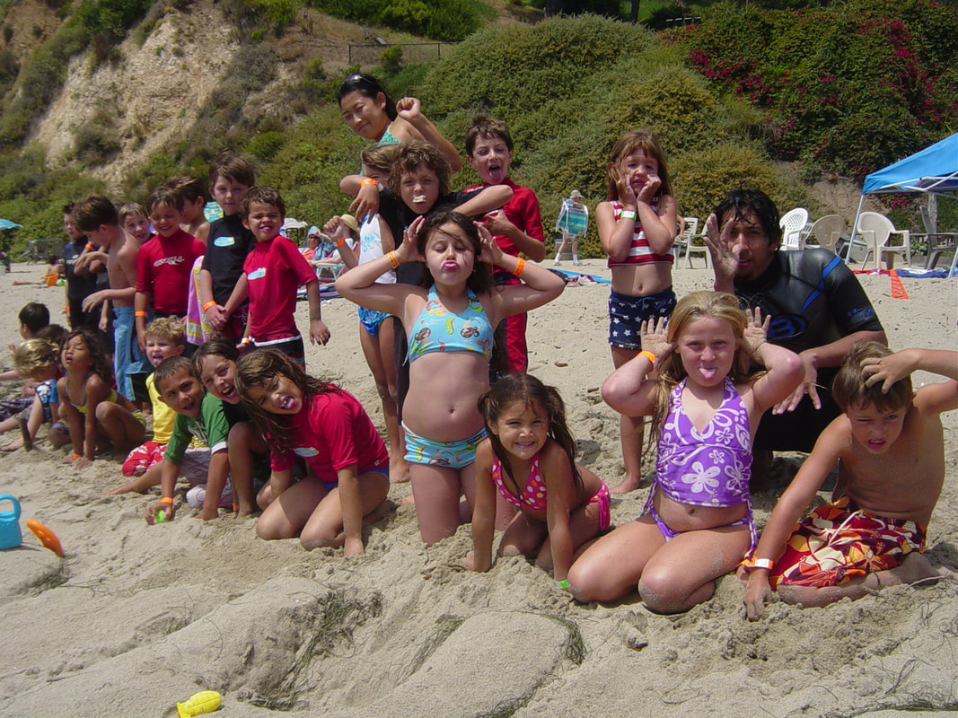 Hawaii summer camp participants making funny faces for a group photo shot on the beach.