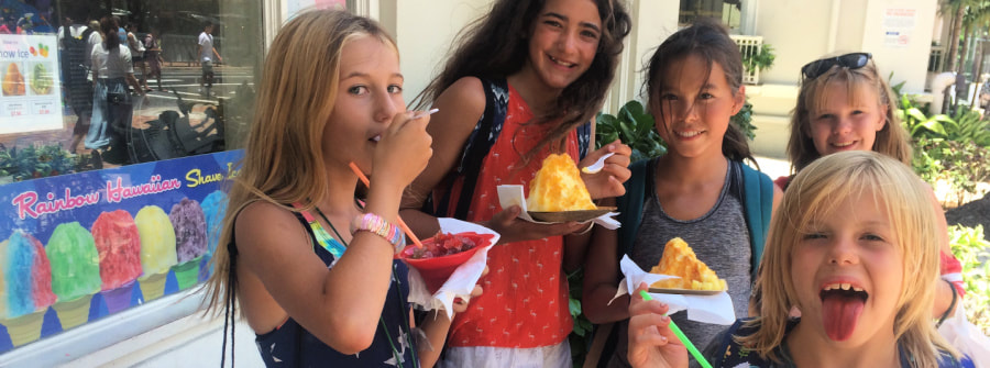 5 girls at Summer Camp in Hawaii enjoying shave ice in front of a shave ice store.