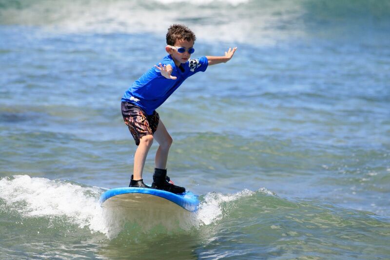 Boy surfing in Hawaii at Aloha Beach Camp's 2021 Hawaii summer camp program.