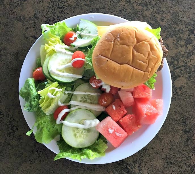 Hawaii summer camp lunch plate consisting of a Hamburger and salad from Aloha Beach Camp, Hawaii.