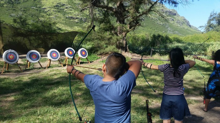 Two campers enjoying Aloha Beach Camp's archery activity at summer camp in Hawaii.