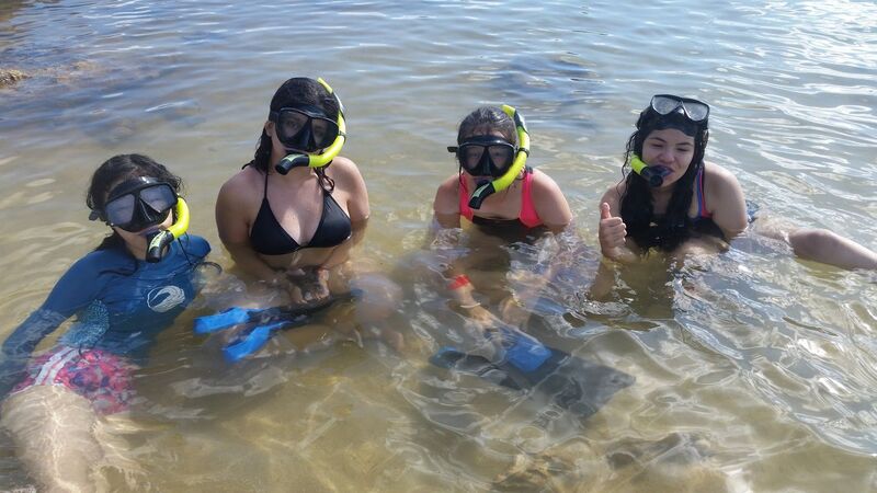 4 girls wearing masks and snorkels at at Aloha Beach Camp in Oahu, Hawaii.