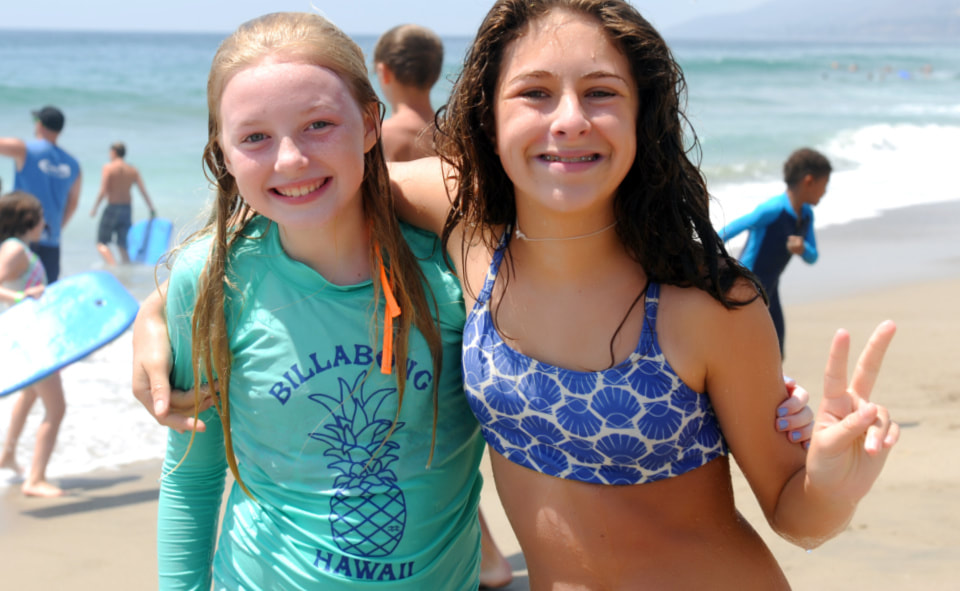 Two girls standing on the beach at surf camp in Hawaii