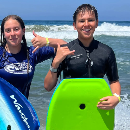 Teenage boy and girl boogie boarding and giving 